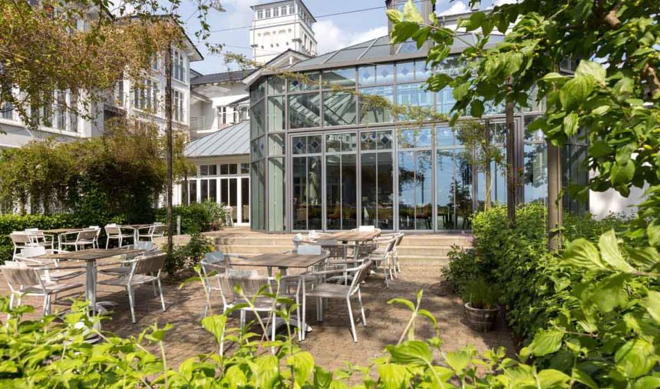 Gemütliche Terrasse des Vju Hotels auf Rügen mit Sitzgelegenheiten im Freien, perfekt zum Frühstücken auf Rügen.