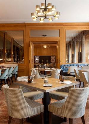 Restaurant AnnA im Hotel Elephant Weimar mit gedeckten Tischen, gepolsterten Stühlen und warmem Holzinterieur.