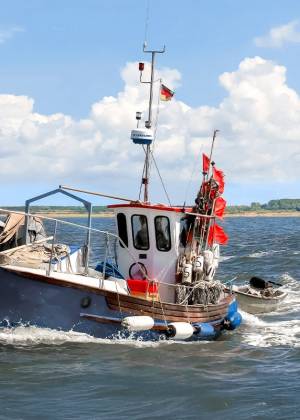Ein traditionelles Fischerboot mit Netzen und Flaggen auf der Ostsee, aufgenommen während der Heringswochen auf Rügen