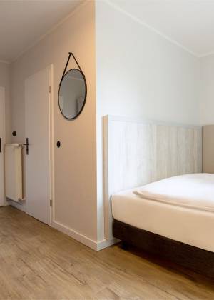 Einzelzimmer des Koopmanns Hotel und Lädchen mit großem Bett und stilvoller Einrichtung.