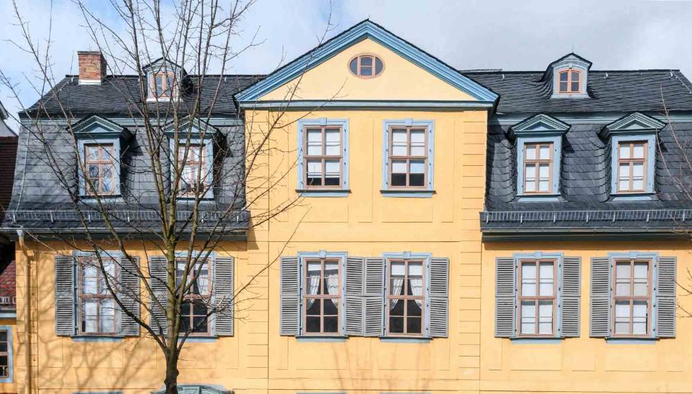 Gelbe Fassade von Schillers Wohnhaus in Weimar mit Mansarddach, Dachgauben und grauen Fensterläden