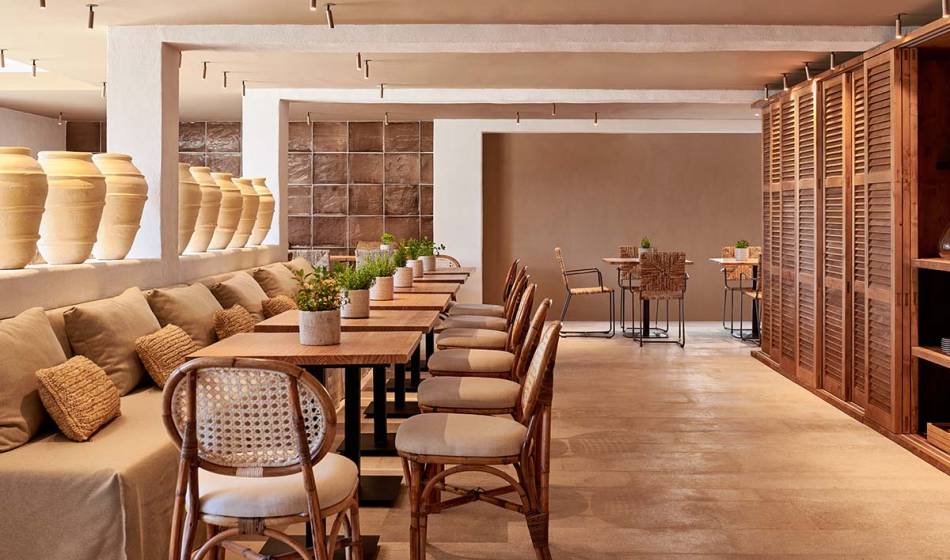 Eleganter Restaurantbereich mit langen Holztischen, gemütlichen Polstersitzen und dekorativen Elementen im Barefoot Hotel Mallorca.