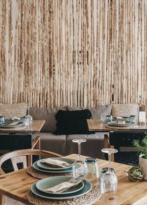 Stilvoll gedeckter Restaurantbereich im Barefoot Hotel Mallorca mit Holzmöbeln und natürlicher Wandgestaltung.