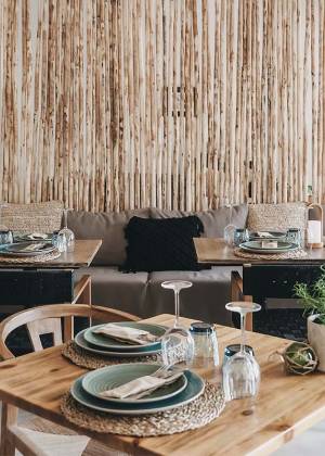 Ein stilvoll gedeckter Tisch mit modernem Geschirr und rustikaler Wanddekoration im Barefoot Restaurant auf Mallorca