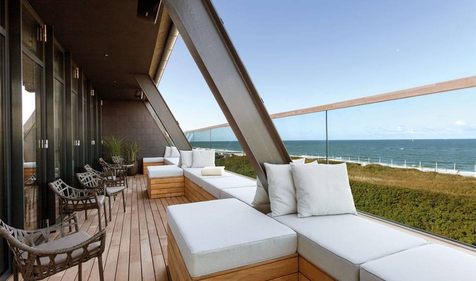 Modern terrace of the NIGHT.LOUNGE in the Wyn. Strandhotel on Sylt with comfortable seating and sea views.