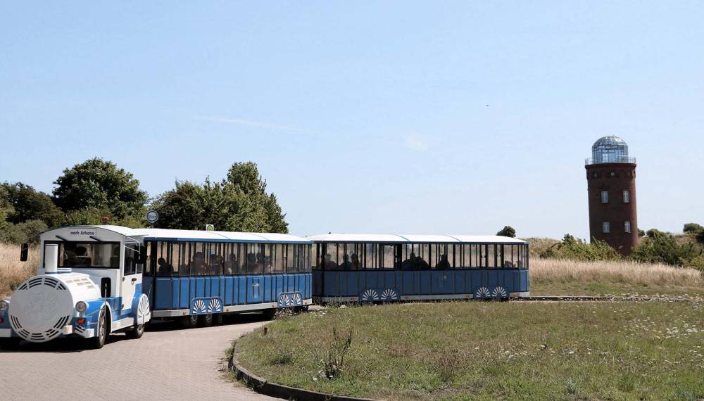 Blau-weiße Bimmelbahn vor dem Peilturm am Kap Arkona auf der Insel Rügen