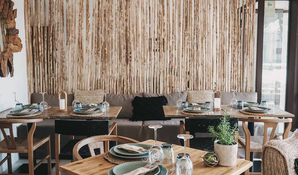 Essbereich mit dekorativen Holztischen, gedeckten Tellern und modernen Elementen in einem gemütlichen Raum im Barefoot Hotel Mallorca.