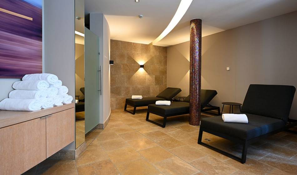 Moderner Ruhebereich mit Liegen und Handtüchern im Wellnessbereich des Hotel Seezeichen in Ahrenshoop.