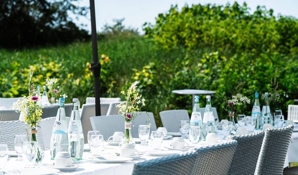 Elegant outdoor wedding table, surrounded by nature, with glasses and flower decorations at the Hotel Seezeichen on the Baltic Sea.