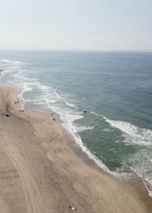 Luftaufnahme des weitläufigen Strandes von Sylt mit der Nordsee im Hintergrund zu sehen bei Anreise mit Flugzeug.