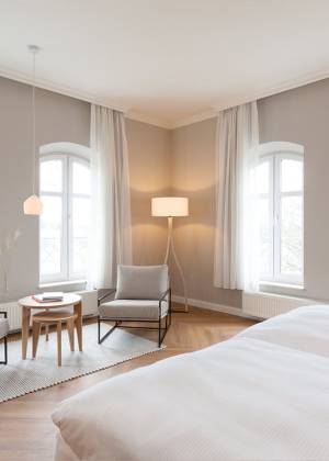 Modern eingerichtete, lichtdurchflutete Familiensuite des Vju Hotel Rügens mit heller Einrichtung.