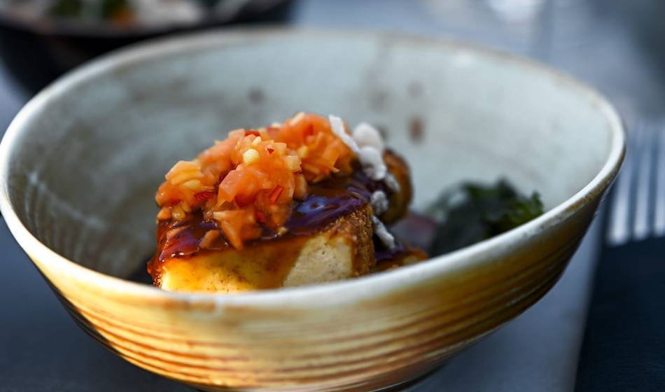 Schüssel mit gebratenem Gericht, garniert mit frischen Toppings und aromatischer Sauce im #herrhoshi auf dem Darß.