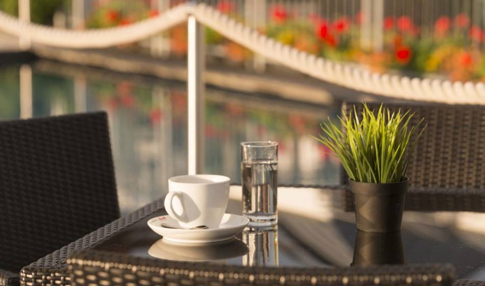 Kaffeetasse und Glas Wasser im Sommergarten des Kaiserhof Heringsdorf auf Usedom.