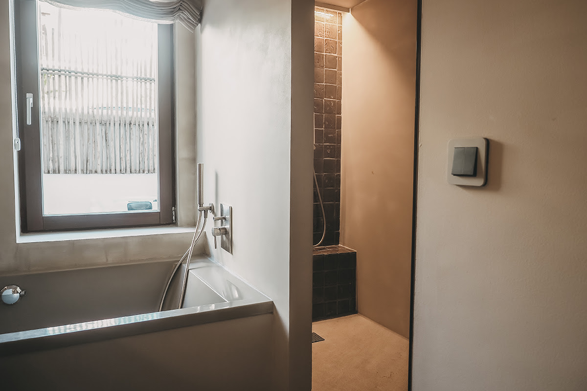 Helles Bad mit Wanne und begehbarer Dusche im Pueblo-Zimmer des Barefoot Hotel Mallorca für entspannende Wellness-Momente.