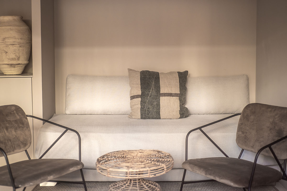 Gemütliche Sitzecke im Zimmer Pueblo des Barefoot Hotel Mallorca mit Sofa und modernen Sesseln.