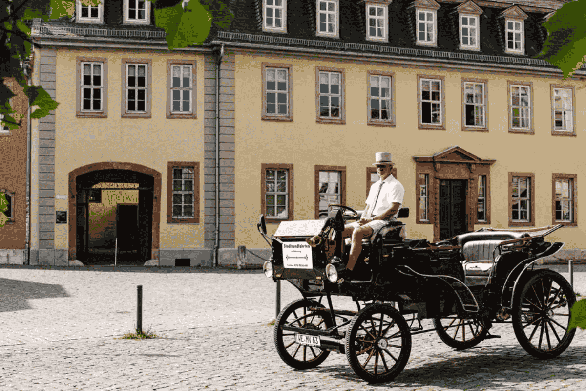 Historische Kutsche mit Kutscher vor dem Goethehaus auf dem gepflasterten Frauenplan.