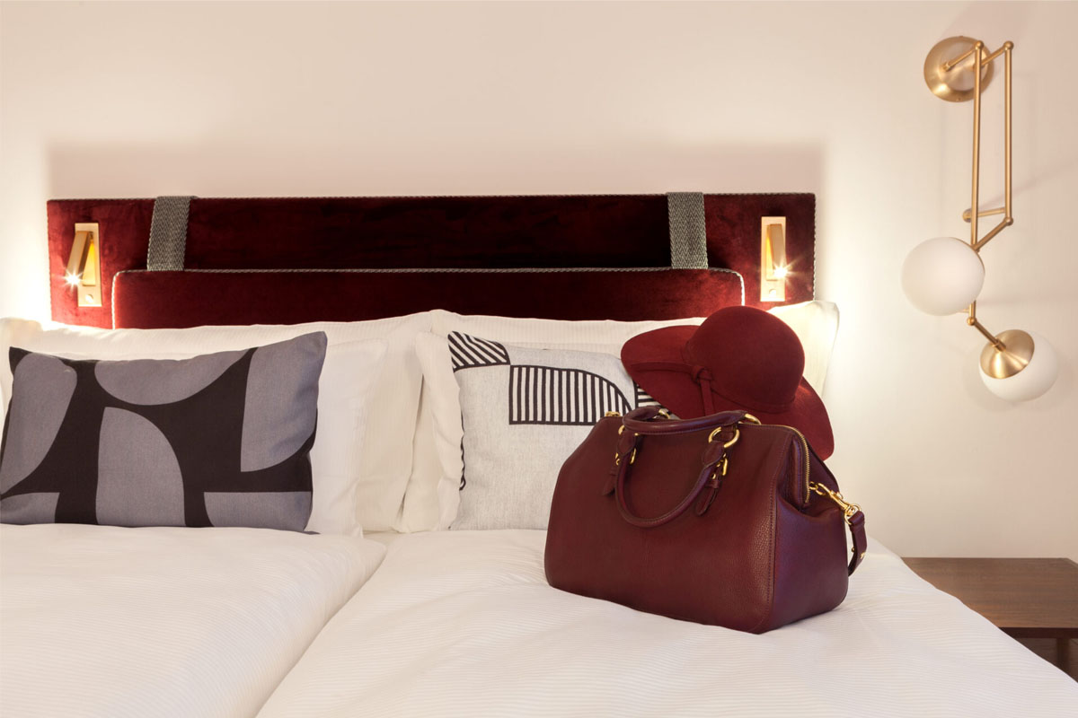 Elegantes Zimmer mit rotem Kopfteil und Dekoration im Hotel Elephant Weimar für einen Sommerurlaub.