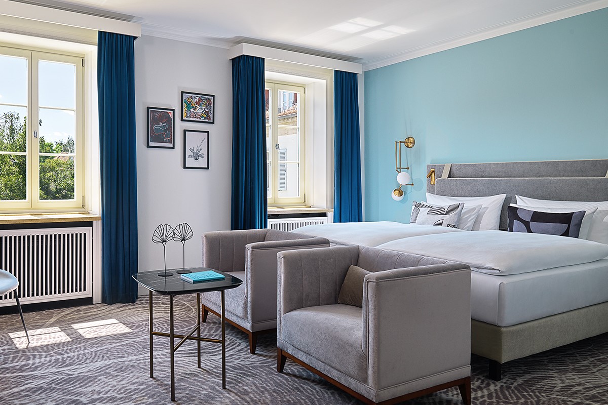 Helles und modernes Hotelzimmer im Hotel Elephant Weimar mit stilvoller Einrichtung und großen Fenstern mit Ausblick.