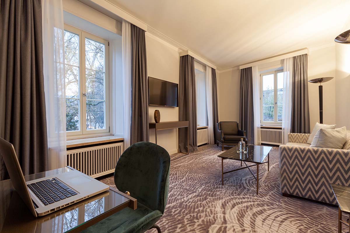 Elegantes Wohnzimmer mit moderner Einrichtung und Blick auf den Garten in der Executive Suite im Hotel Elephant Weimar.
