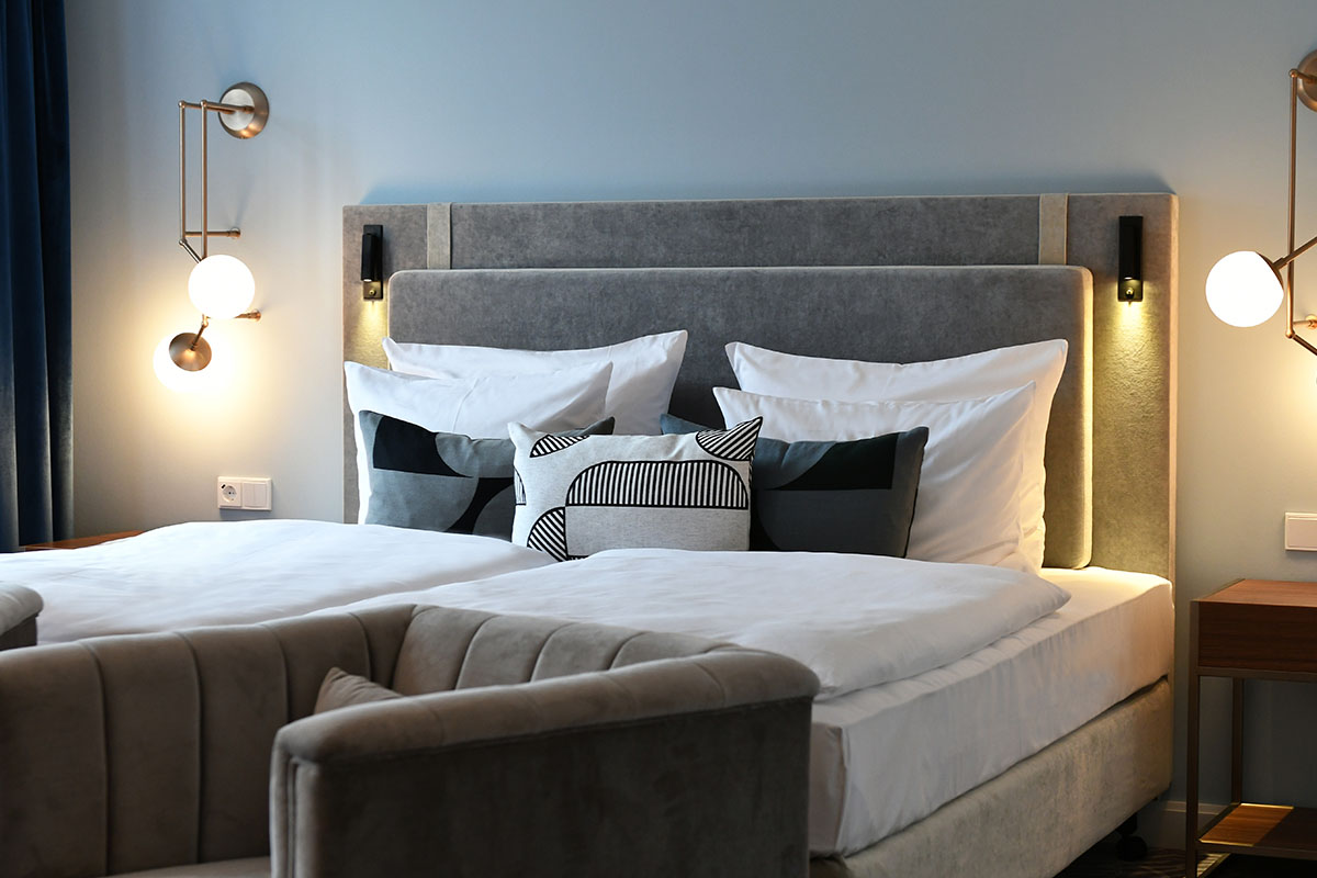Luxuriöses Bett mit weichen Kissen und warmer Beleuchtung für erholsame Nächte in der Junior-Suite im Hotel Elephant.