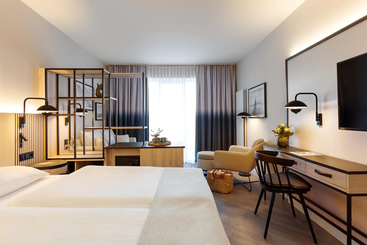 Modernes Hotelzimmer im Hotel Kaiserhof Heringsdorf mit Doppelbett und gemütlicher Sitzecke, perfekt für das Frühlingsspecial.