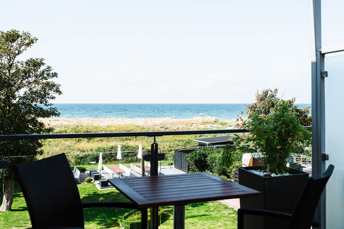 Privater Balkon mit Blick über Garten und Dünen auf die Ostsee, perfekt für eine Auszeit im Hotel Küstlerquatier Seezeichen.