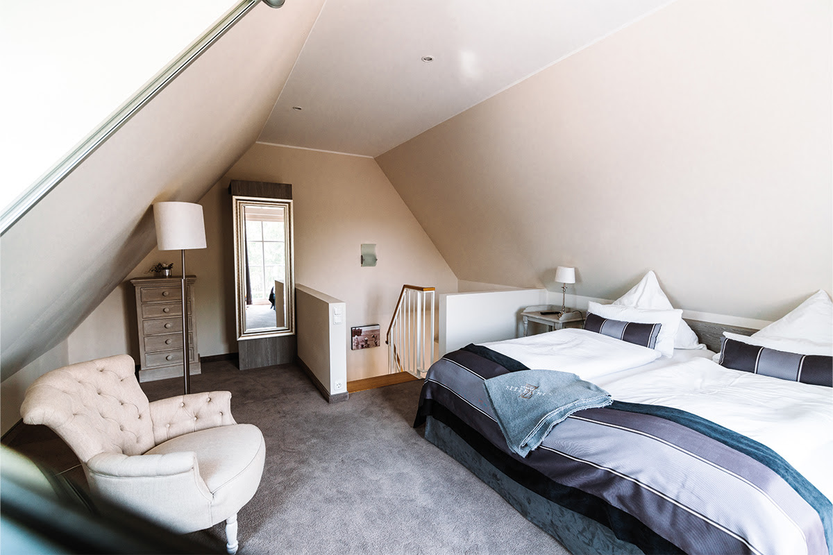 Comfortable double bed in the bedroom of the Seepferd vacation apartment in the dune park of the Hotel Künstlerquartier Seezeichen.