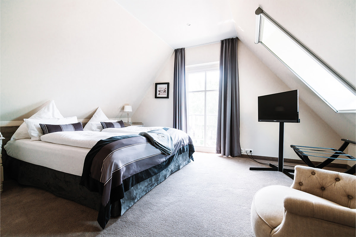 Bright bedroom with king-size bed for a peaceful break in the Seepferd vacation apartment in the Hotel Künstlerquartier Seezeichen.