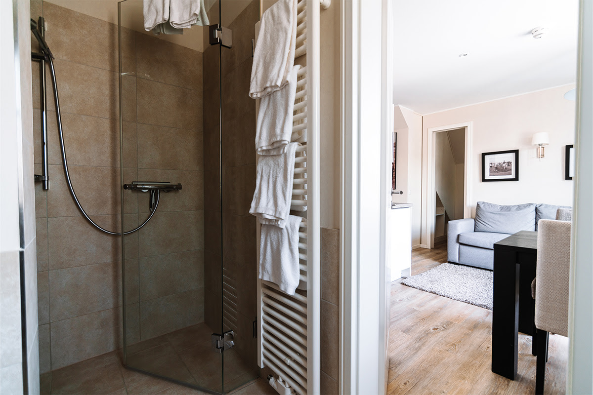 Modern glass shower in the bathroom of the Stranddüne vacation apartment in the Hotel Künstlerquartier Seezeichen in Ahrenshoop.