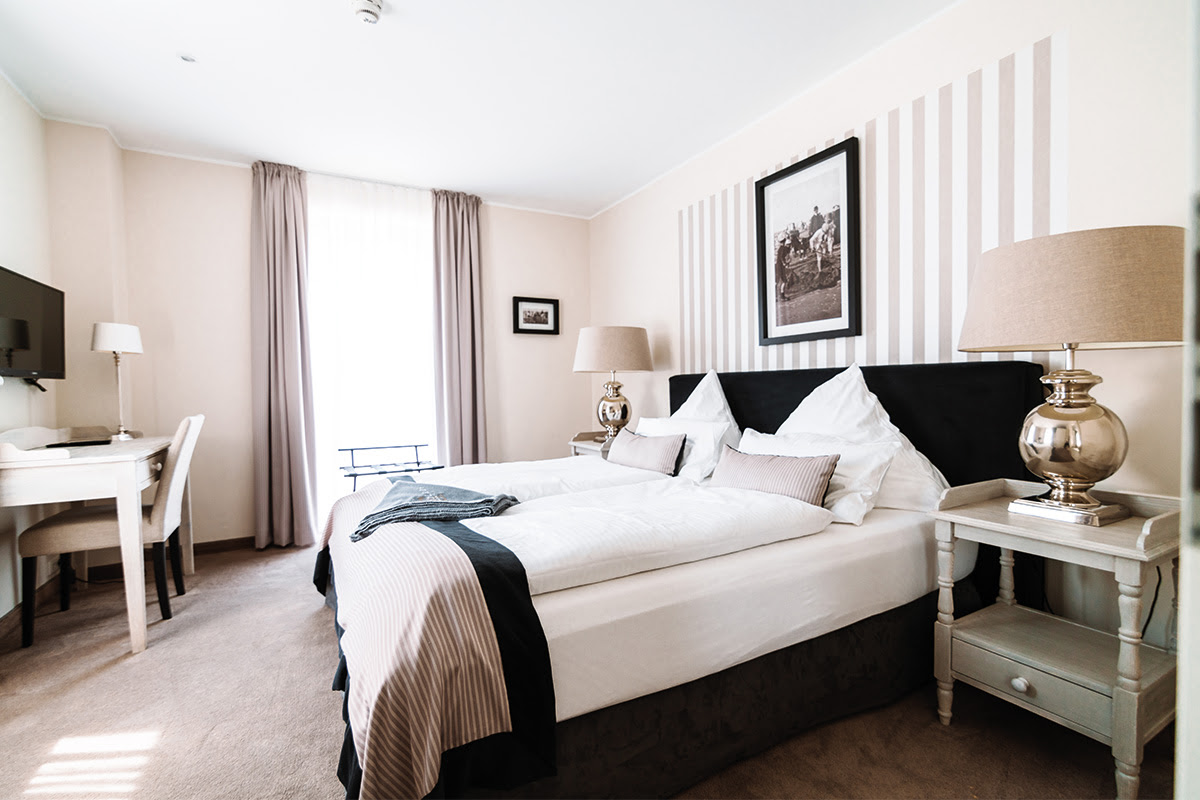 Bedroom with luxurious furnishings and natural light in the Strandmuschel vacation apartment in the Ahrenshoop Dune Park.