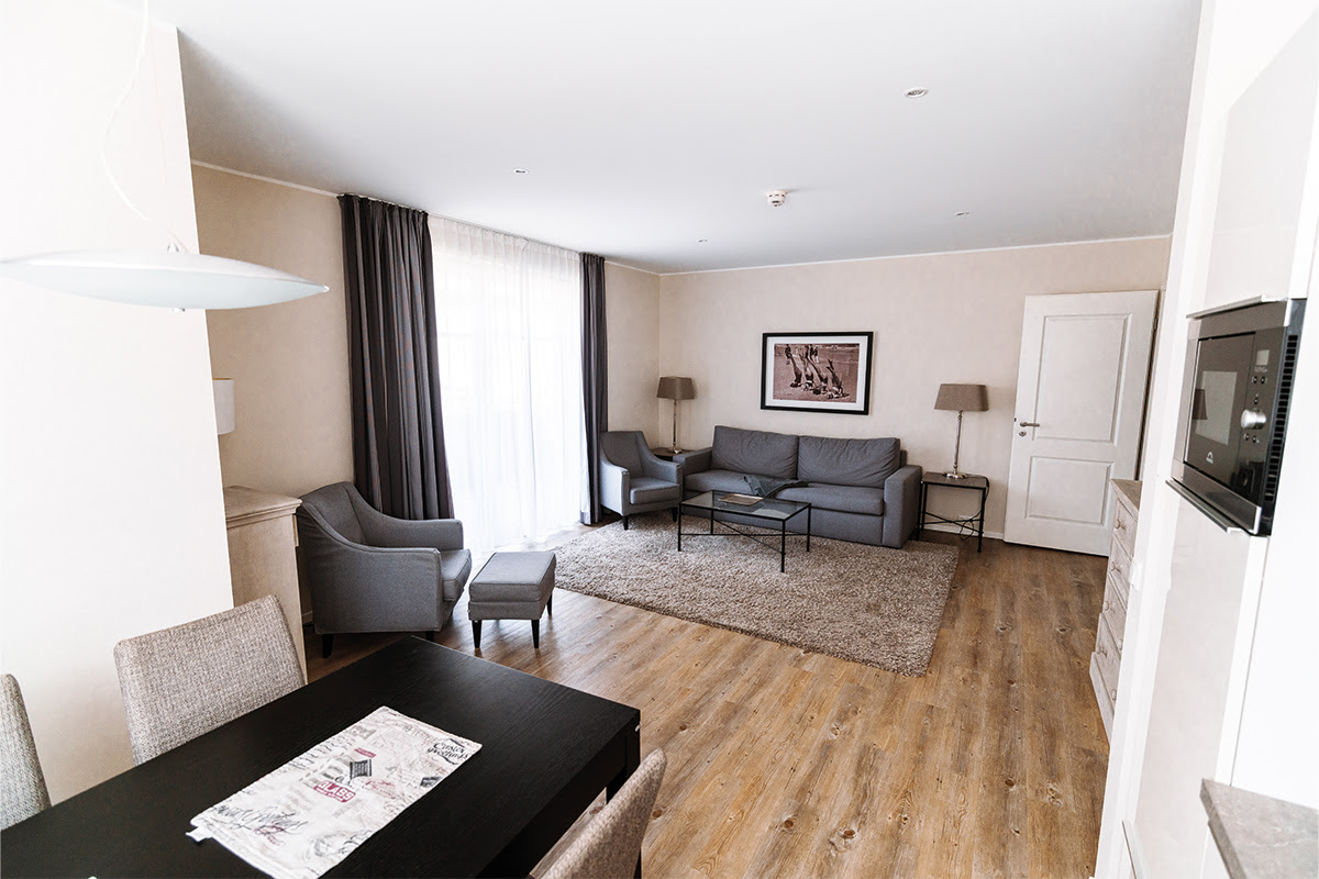 Bright dining and living room with comfortable seating in the Strandmuschel vacation apartment in the Hotel Künstlerquartier Seezeichen.