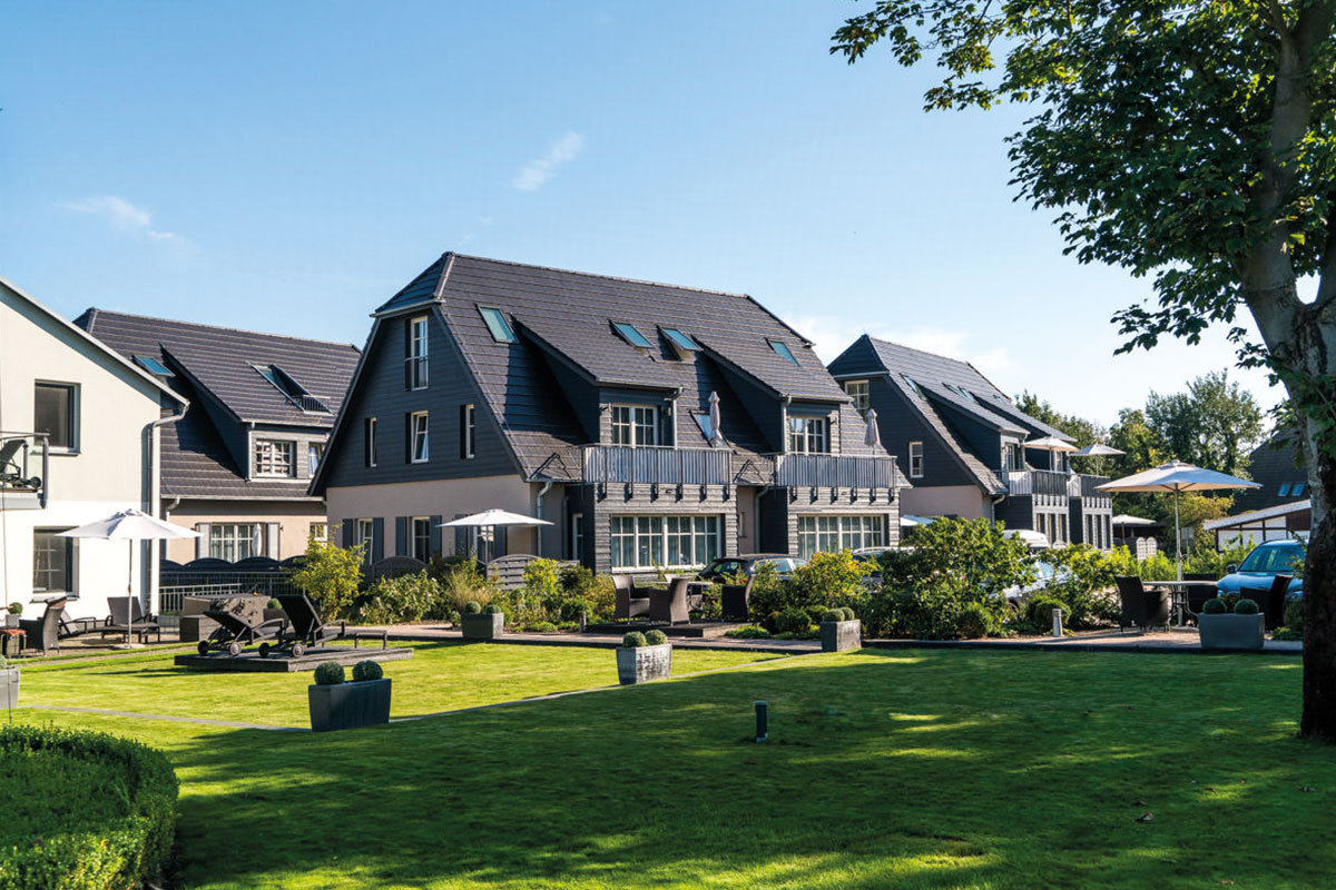 Ansicht der gepflegten Ferienanlage Dünenpark mit grüner Gartenfläche, Teil des Hotel Künstlerquartier Seezeichen.