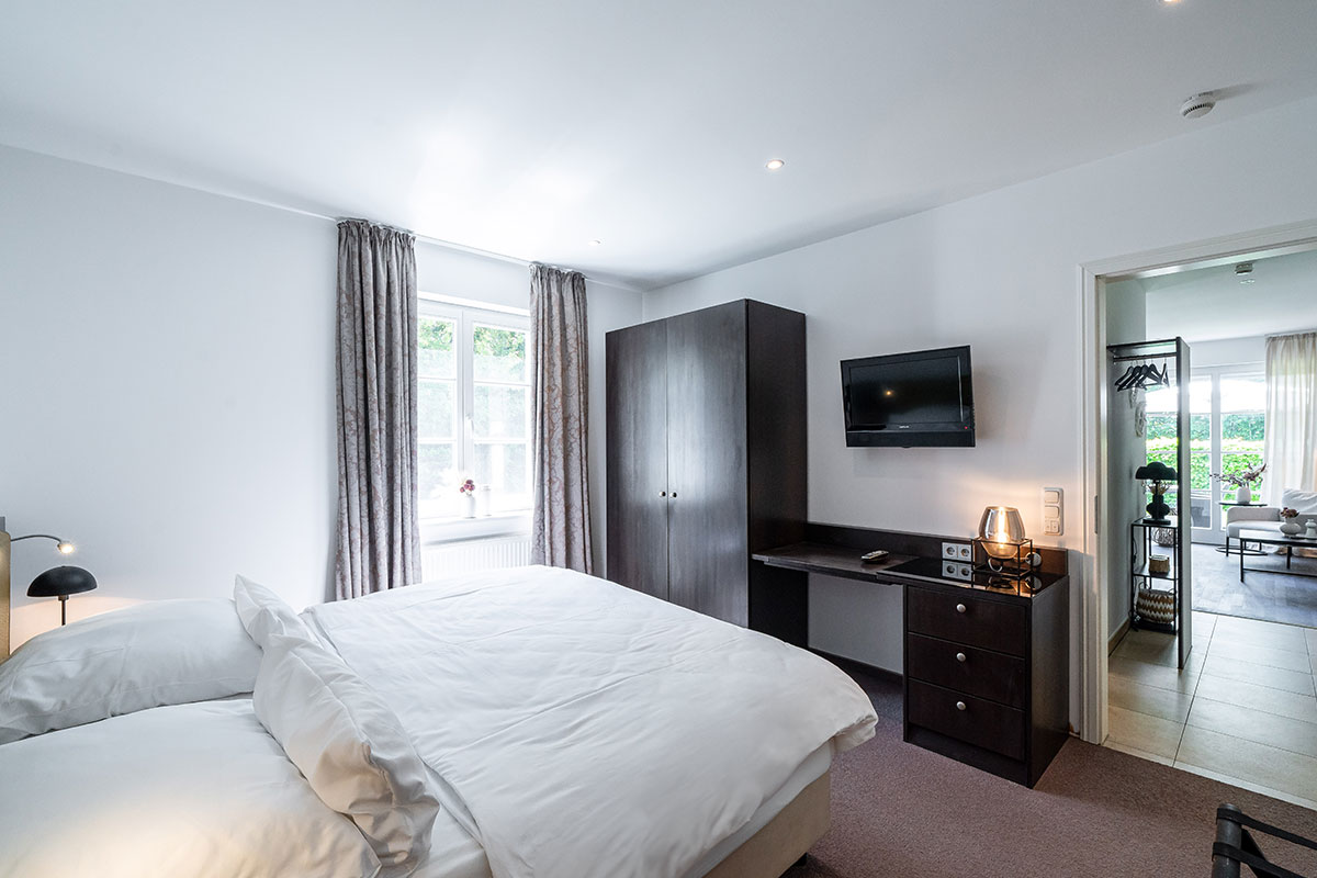Modern furnished bedroom with double bed and large window in the Seeschwalbe vacation apartment in the residence in Ahrenshoop.