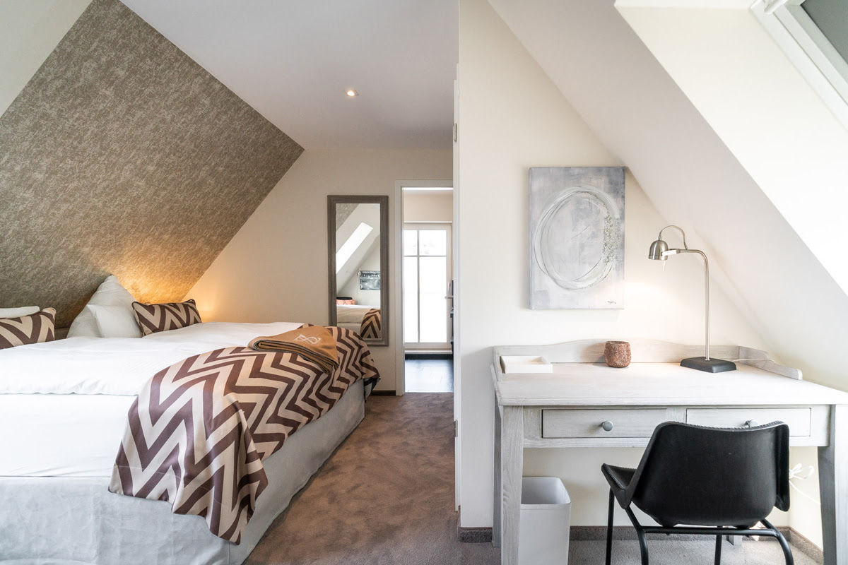 Attic bedroom with cozy bed in the Strandjuwel vacation apartment in the Hotel Künstlerquartier Seezeichen.