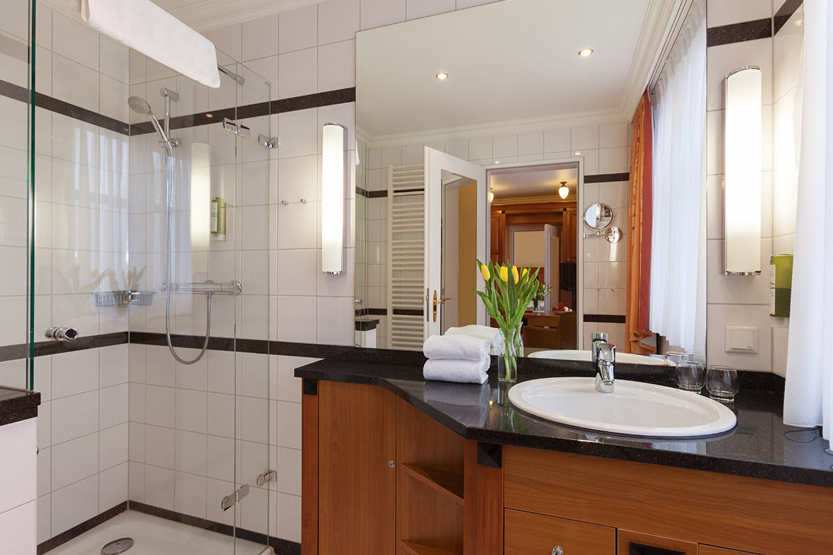 Helles Badezimmer mit eleganter Ausstattung und großer Dusche im Doppelzimmer in den Dependancen im Vju Hotel.