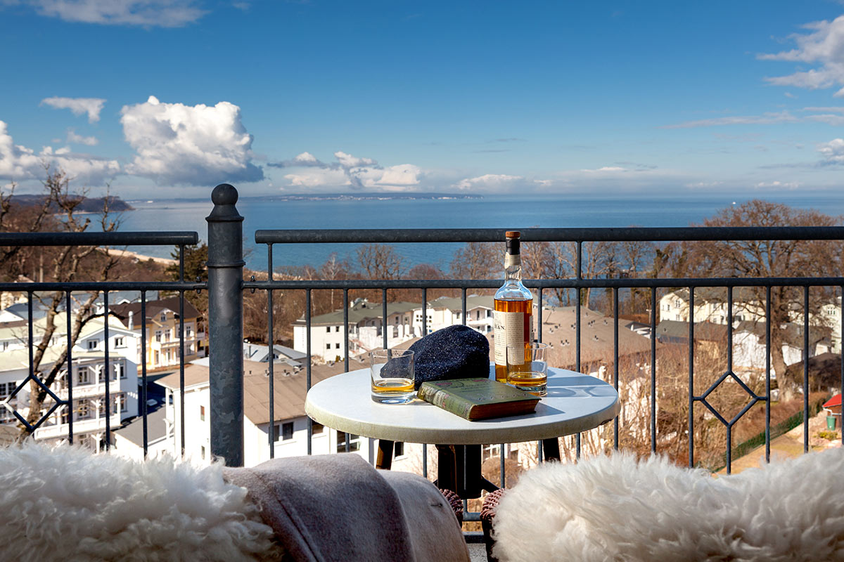 Gemütlicher Balkon mit Meerblick, flauschigen Decken und einem Tisch für entspannte Momente im Vju Hotel.