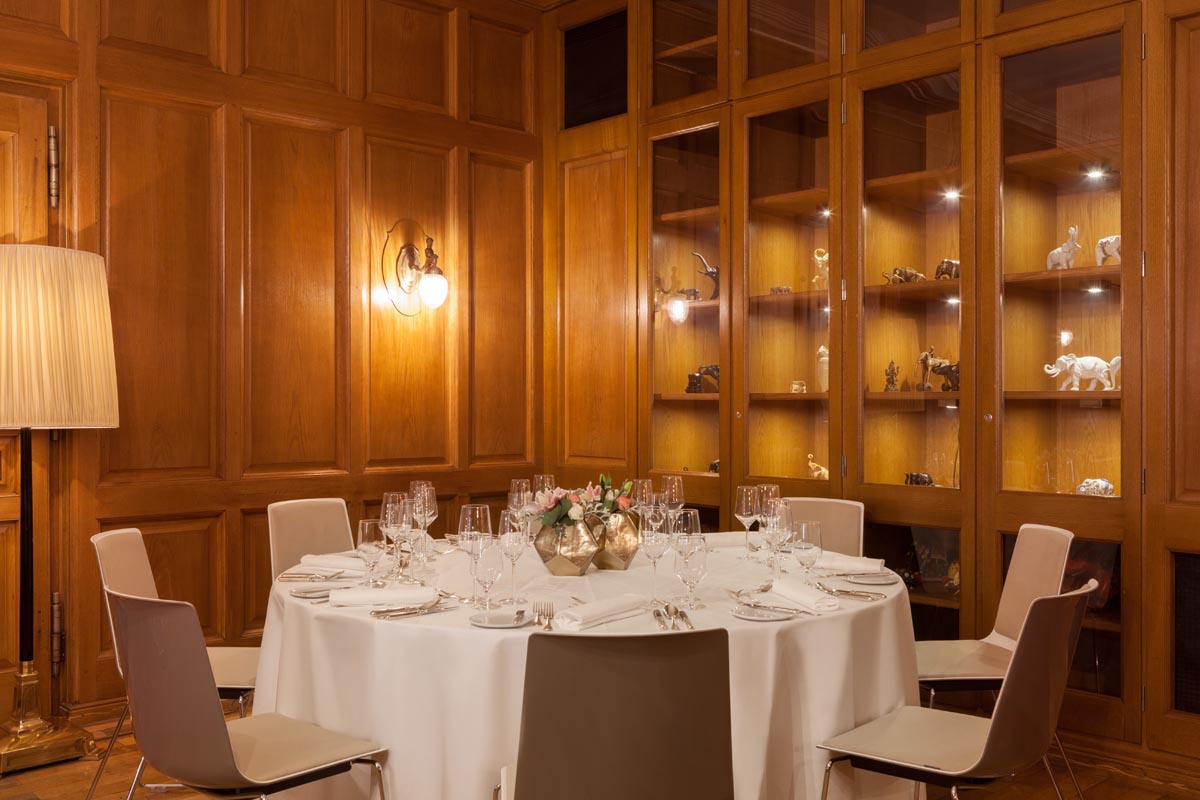 Festlich gedeckter Tisch im privaten Speiseraum des Hotel Elephant Weimar mit Holzvertäfelung und dekorativen Vitrinen.