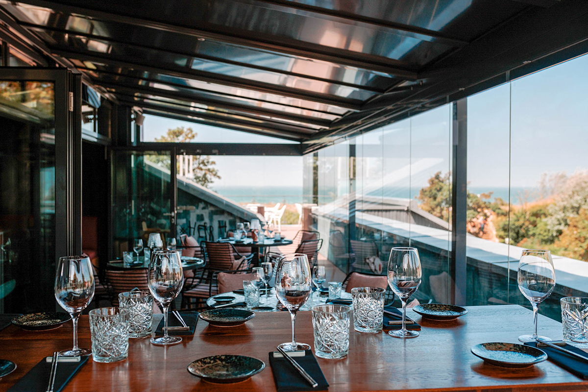 Elegantes Restaurant für Familienfeiern mit gedecktem Tisch, Gläsern und Meerblick im Künstlerquartier Seezeichen.