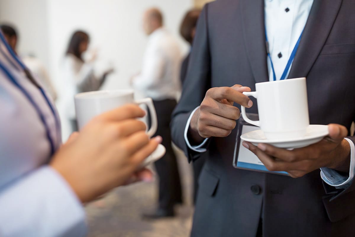 Nahaufnahme von Personen mit Kaffeetassen beim Networking, Tagungsangebot im Künstlerquartier Seezeichen für Events.